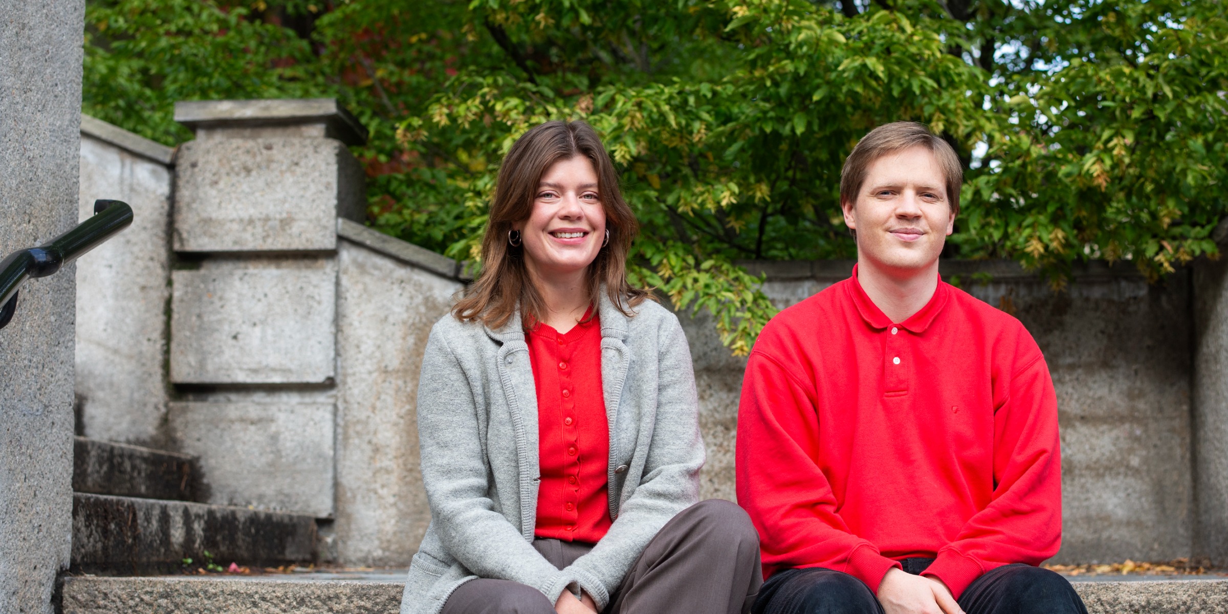 Portrett av studentombudene Rebekka og Martin sittende utendørs i en steintrapp.