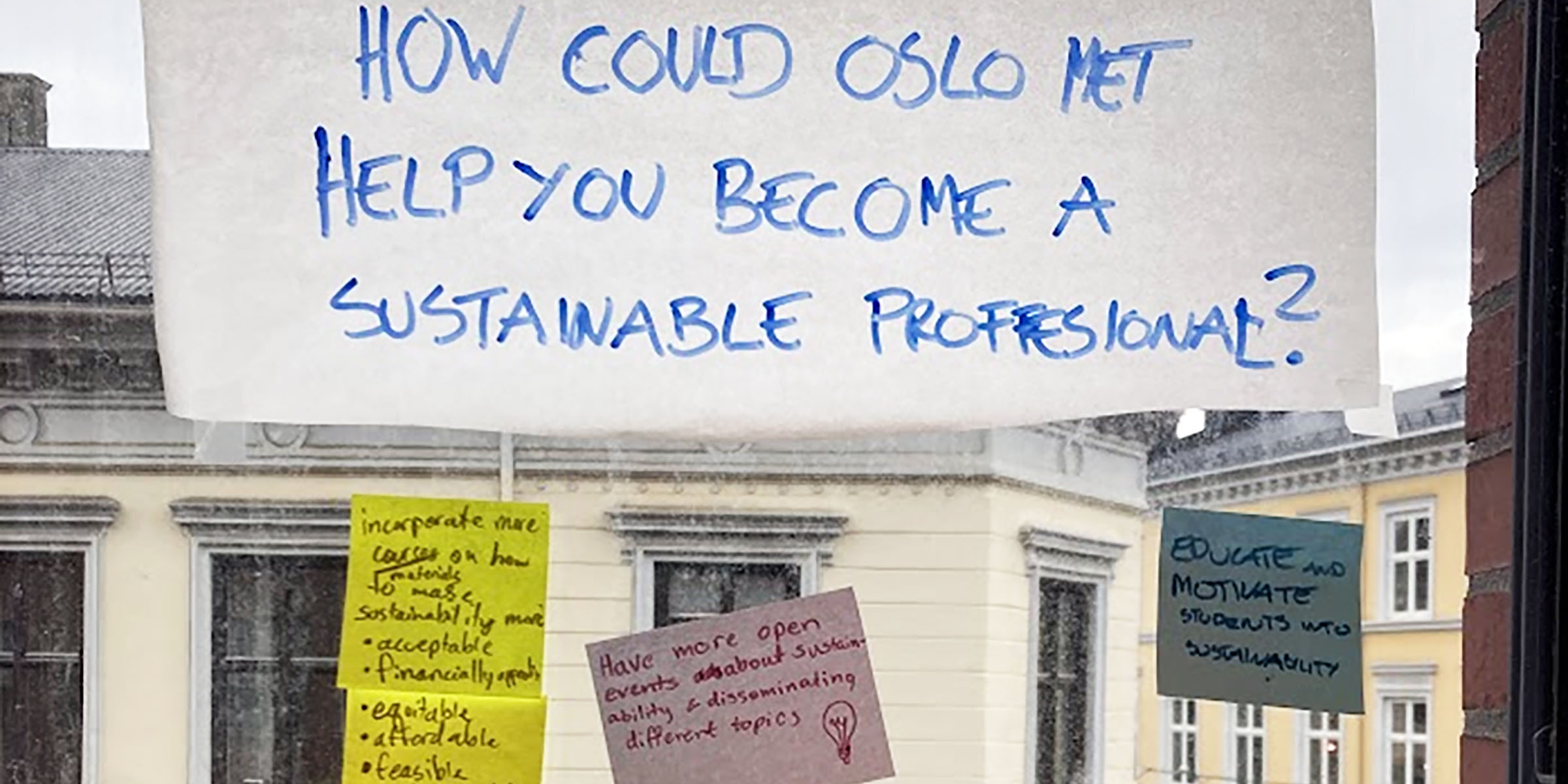 Vindu med påklistrede post-it lapper og ark med tekst om bærekraft.