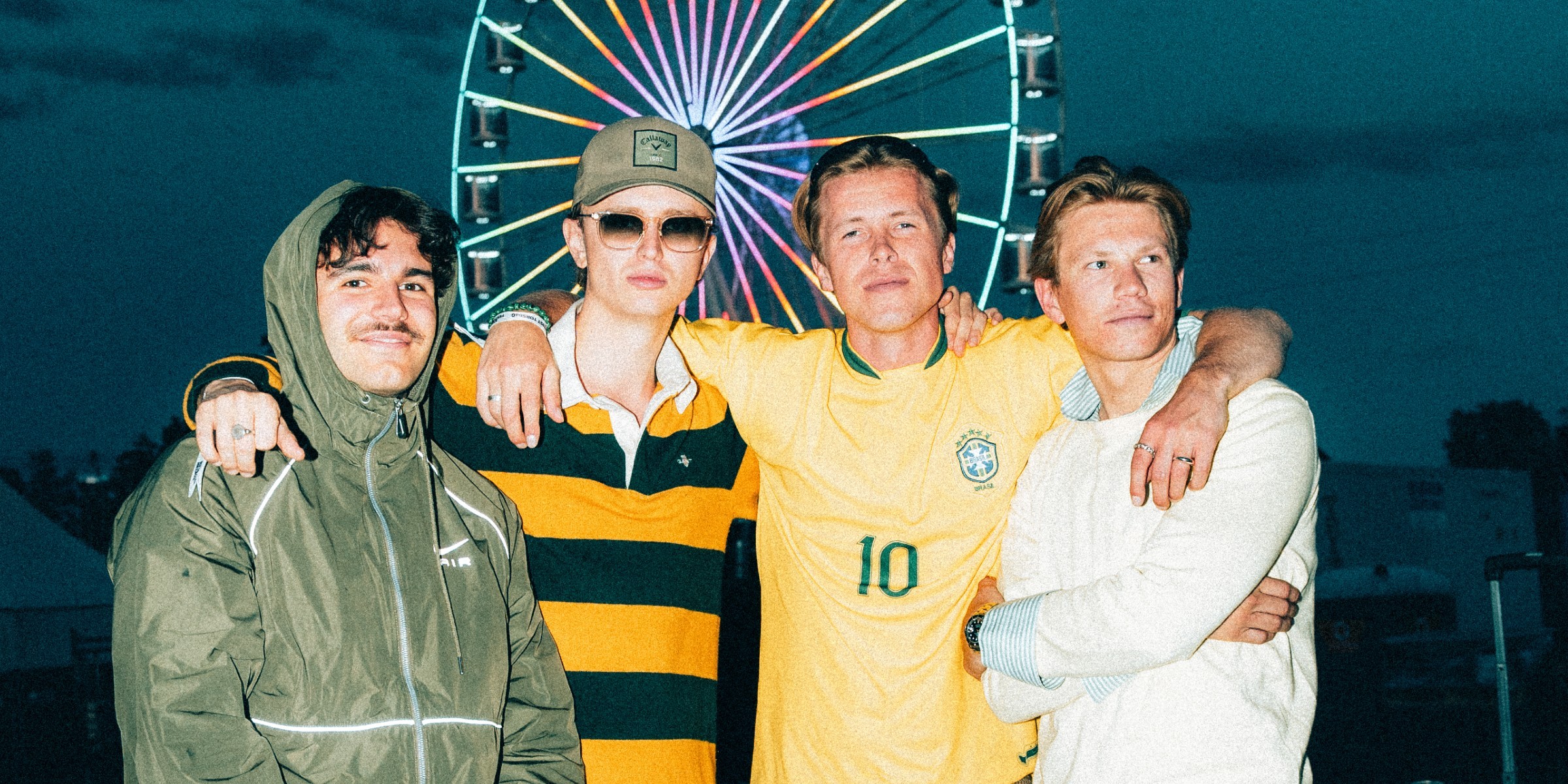 Pressefoto bandet Golf. Fire menn som står foran et pariserhjul.