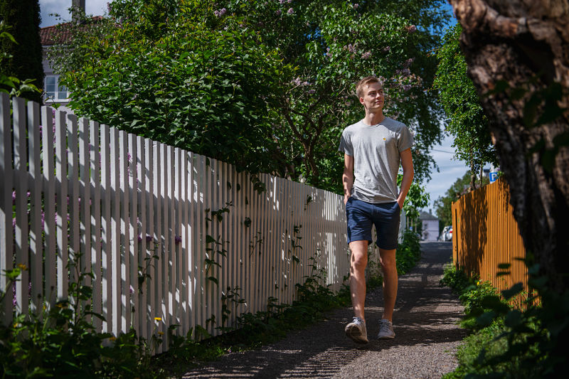 Simen som går langs en sti med gjerder og hager på begge sider.