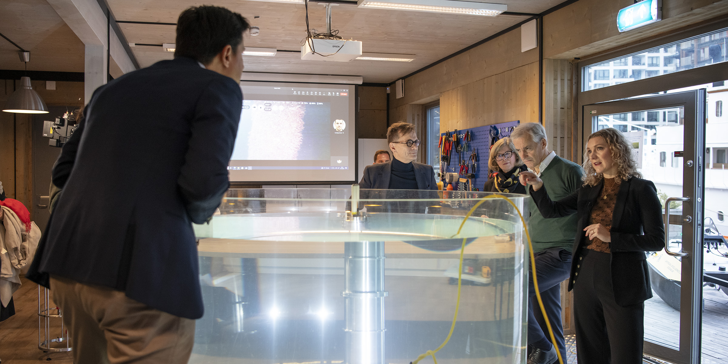 Professor Alex Alcocer by the water tank wich contains the technology developed at the Ocean lab. He demonstrates the equipment to the Prime Minister and the Minister of Digitalisation.