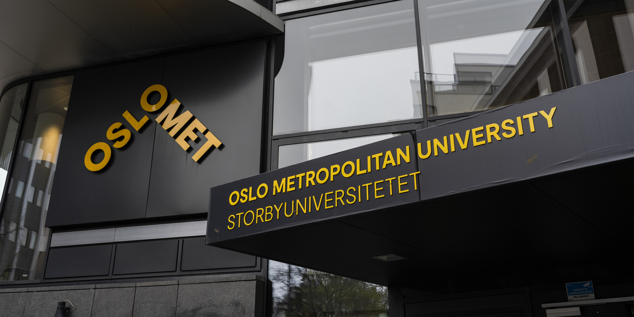 Bilde av et OsloMet-bygg med gul logo og navn på grå vegg.