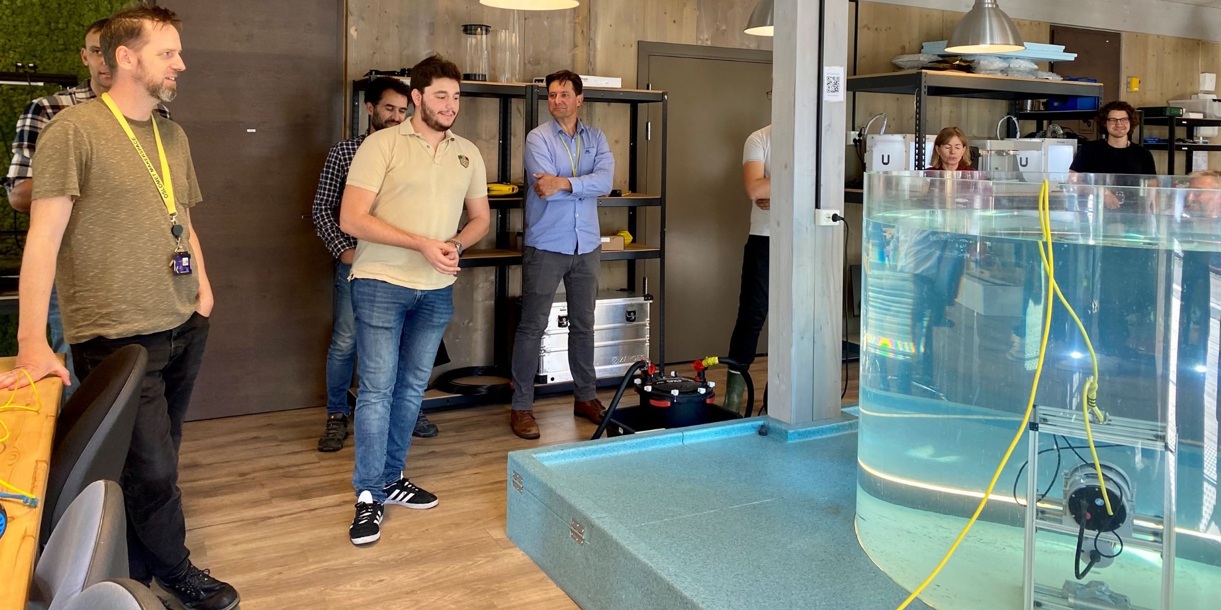 Foto av ansatte ved Oceanlab ved Fakultet for teknologi, kunst og design, OsloMet, som står foran en vanntank er den nye undervannsteknologien testes ut.