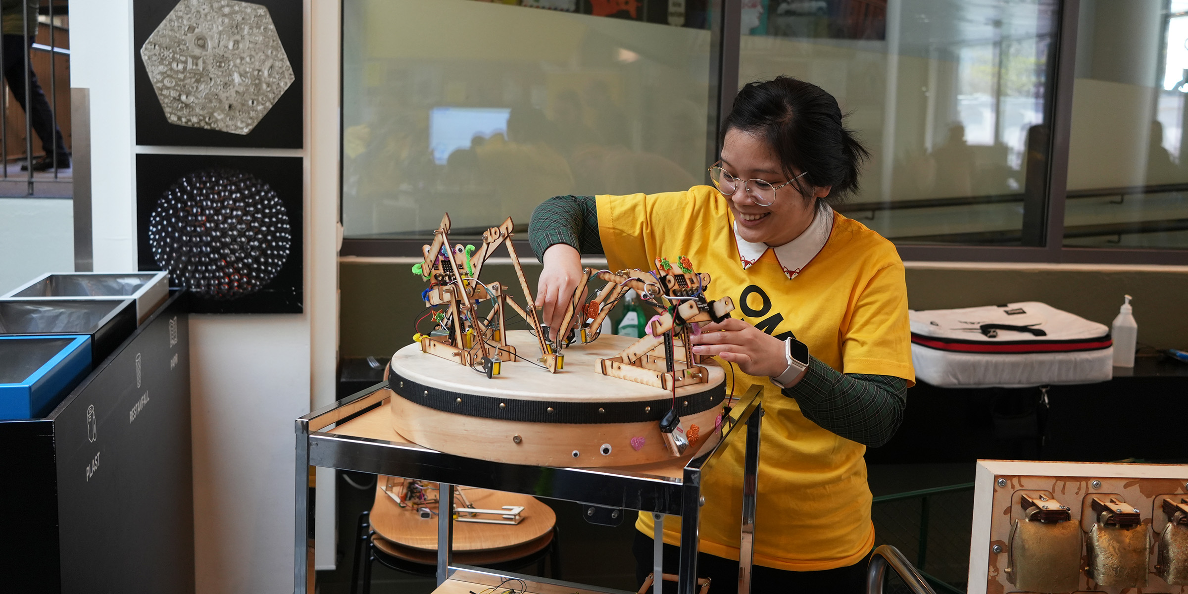 Bilde av OsloMet-student Julianne Pheng som hjelper til med Captain Credibles trillende robotorkester. 
