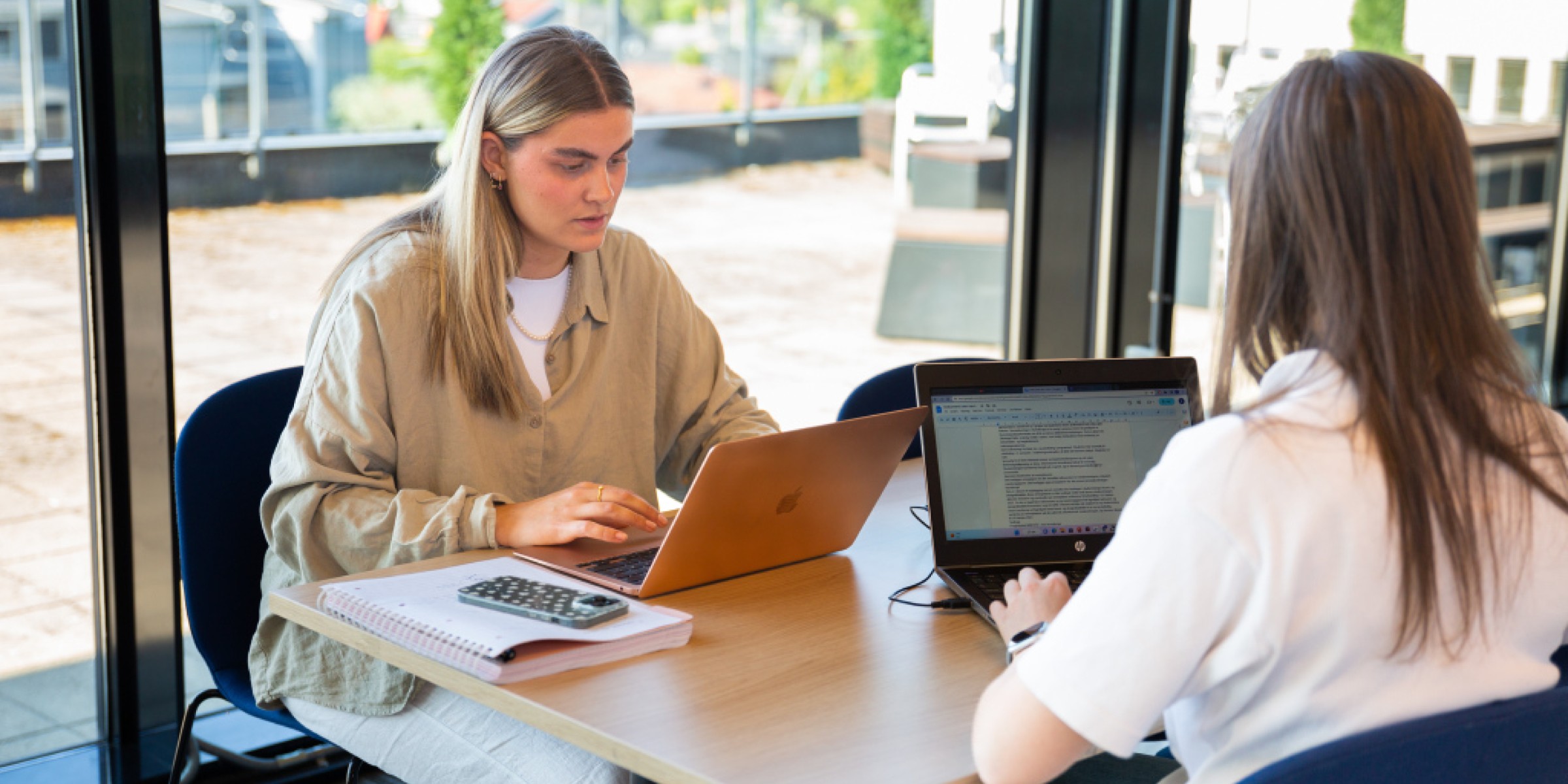 Bilde av to studenter foran hver sin PC.