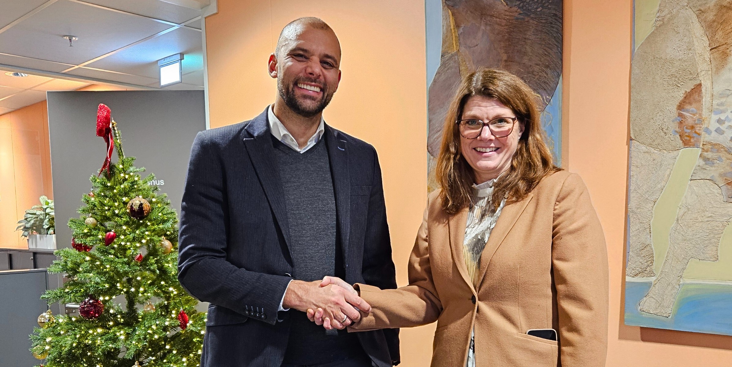Foto av regiondirektør i Bufetat øst, Ingrid Pelin Berg, og prorektor Carl Thodesen fra OsloMet, som gir hverandre et håndtrykk.
