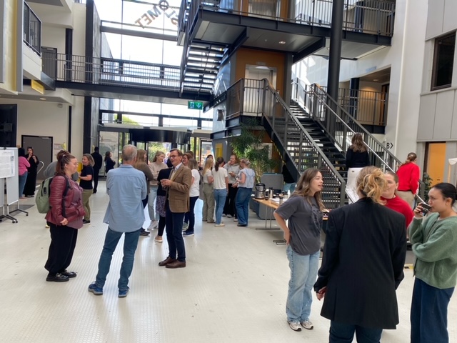 Foto av studenter og ansatte som snakker sammen  i foajeen på campus Kjeller. 