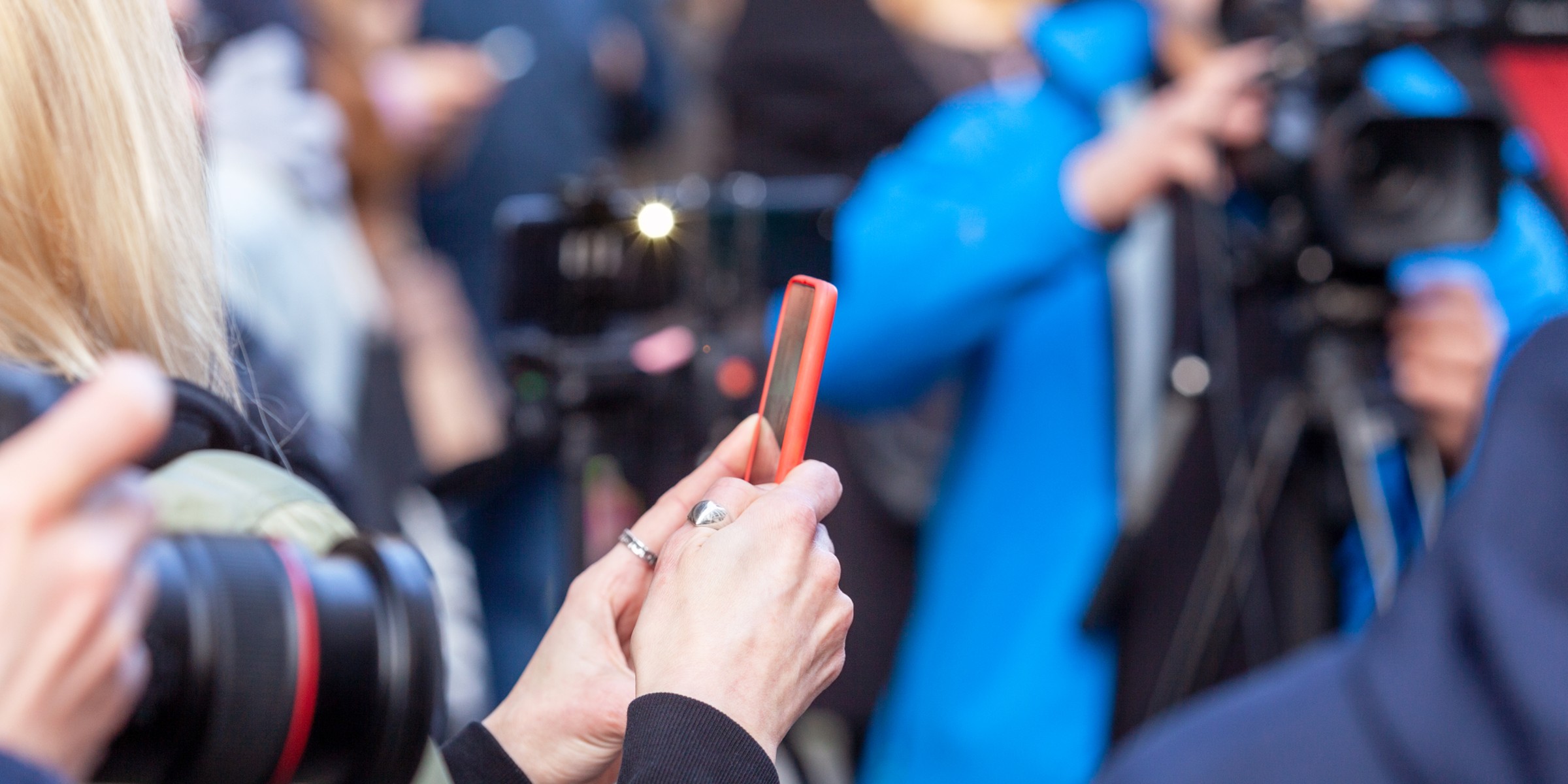 Picture of camera, mobile phone and journalists.