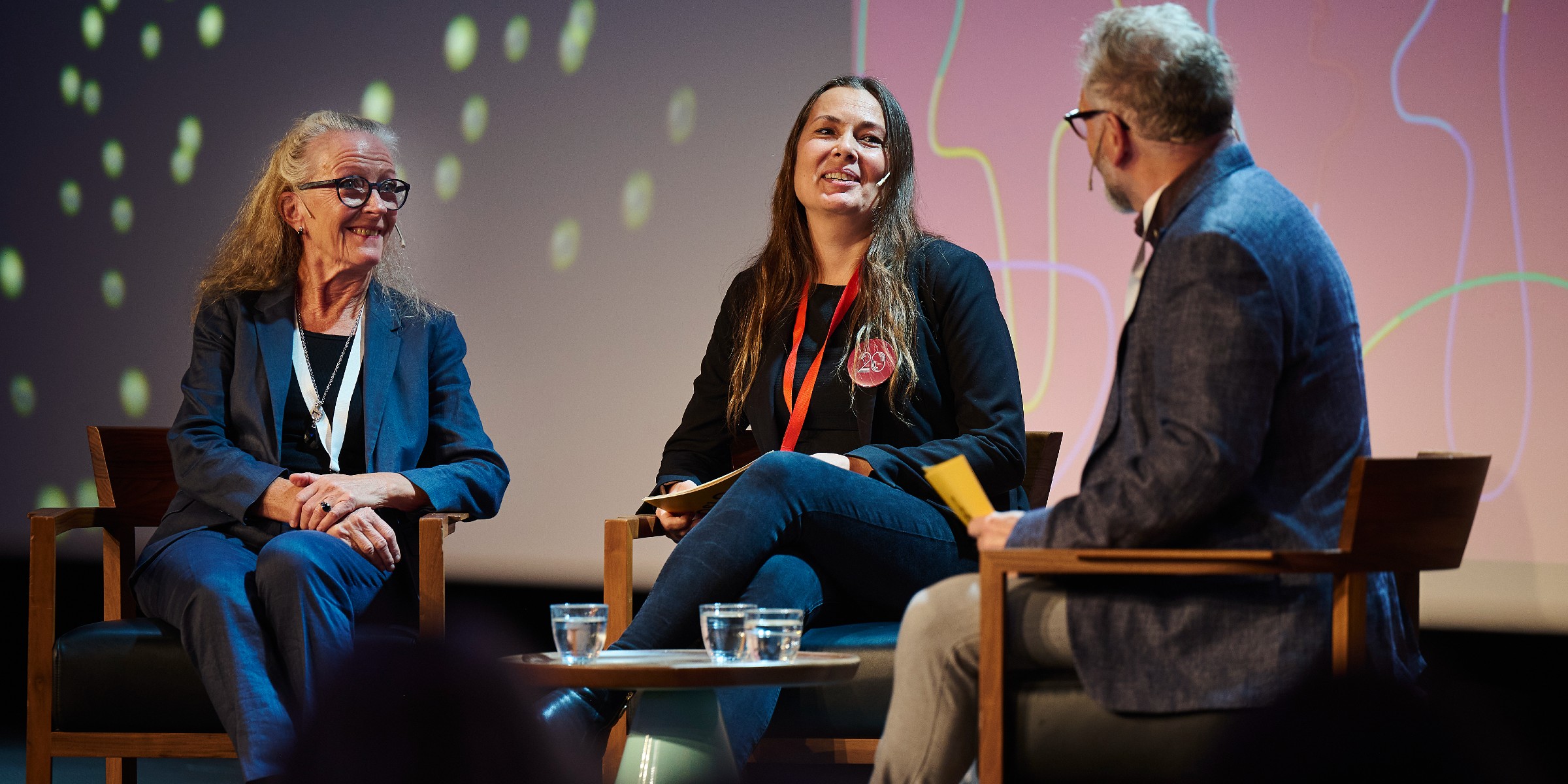 Foto av NAFOs leder Marit Lunde (i midten) som intervjuer to deltakere på en scene under jubileumskonferansen.