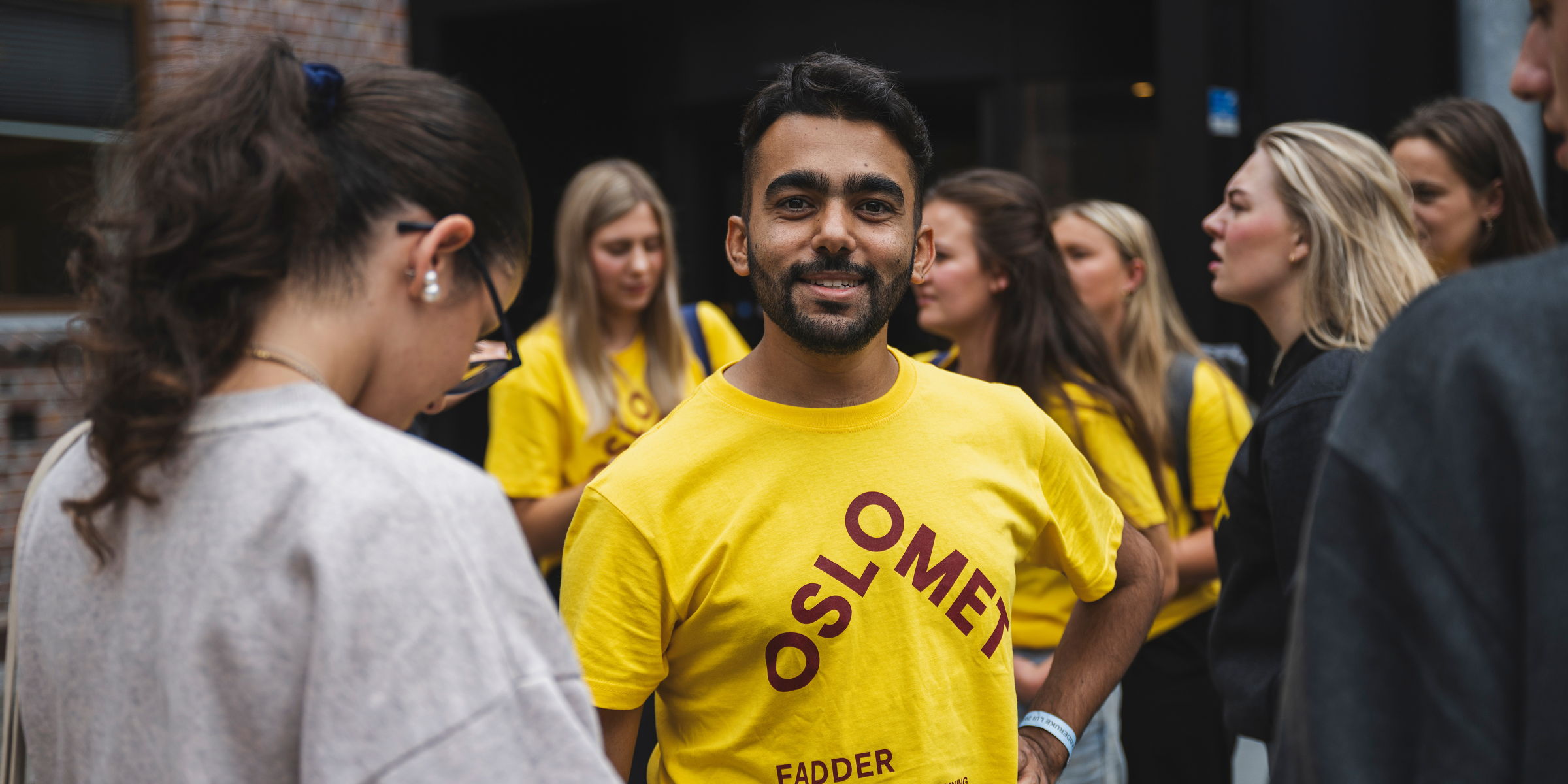 Mann i gul t-skjorte med OsloMet-logo.