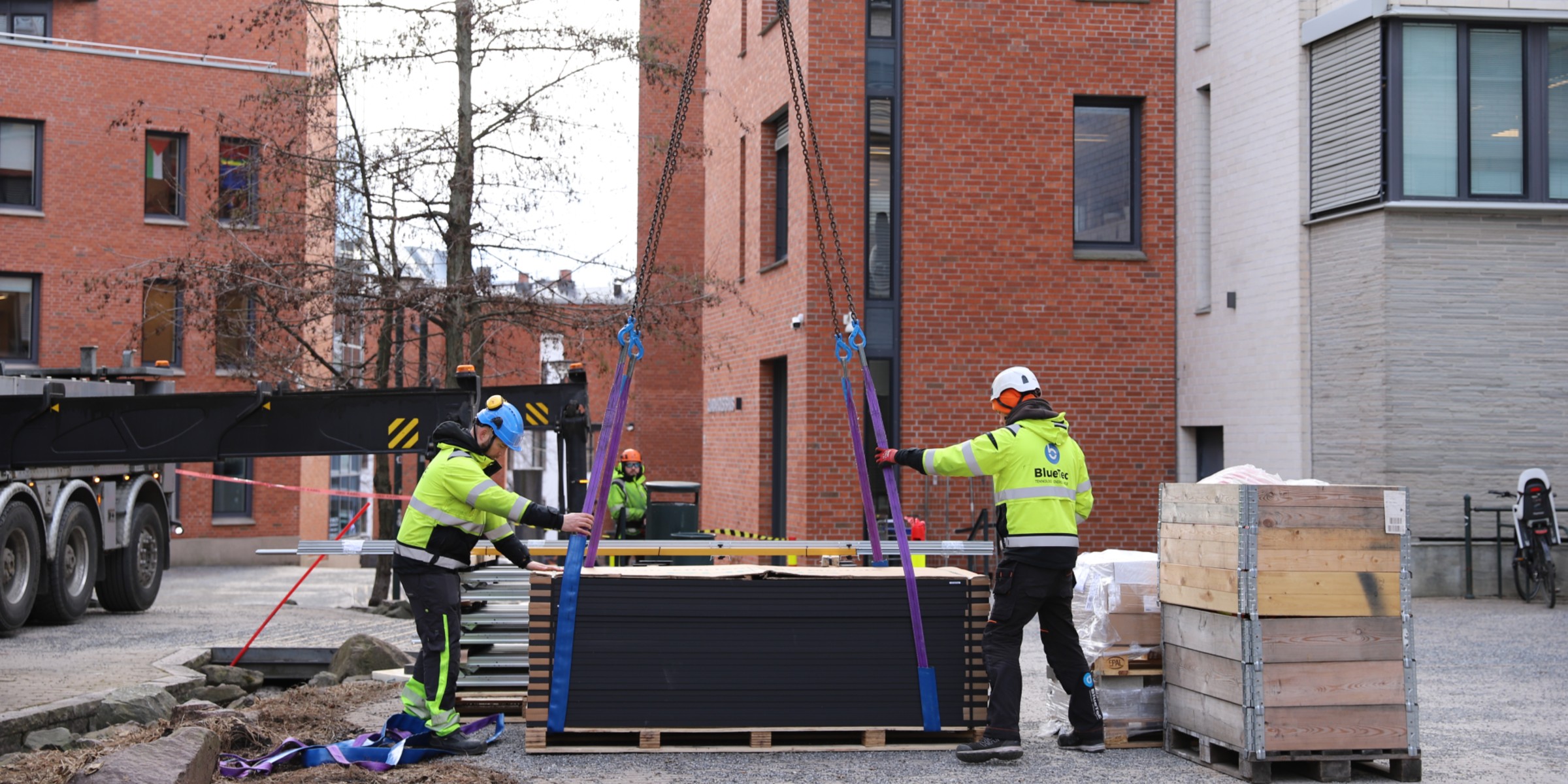 En stabel med solcellepanel som heises opp på taket.