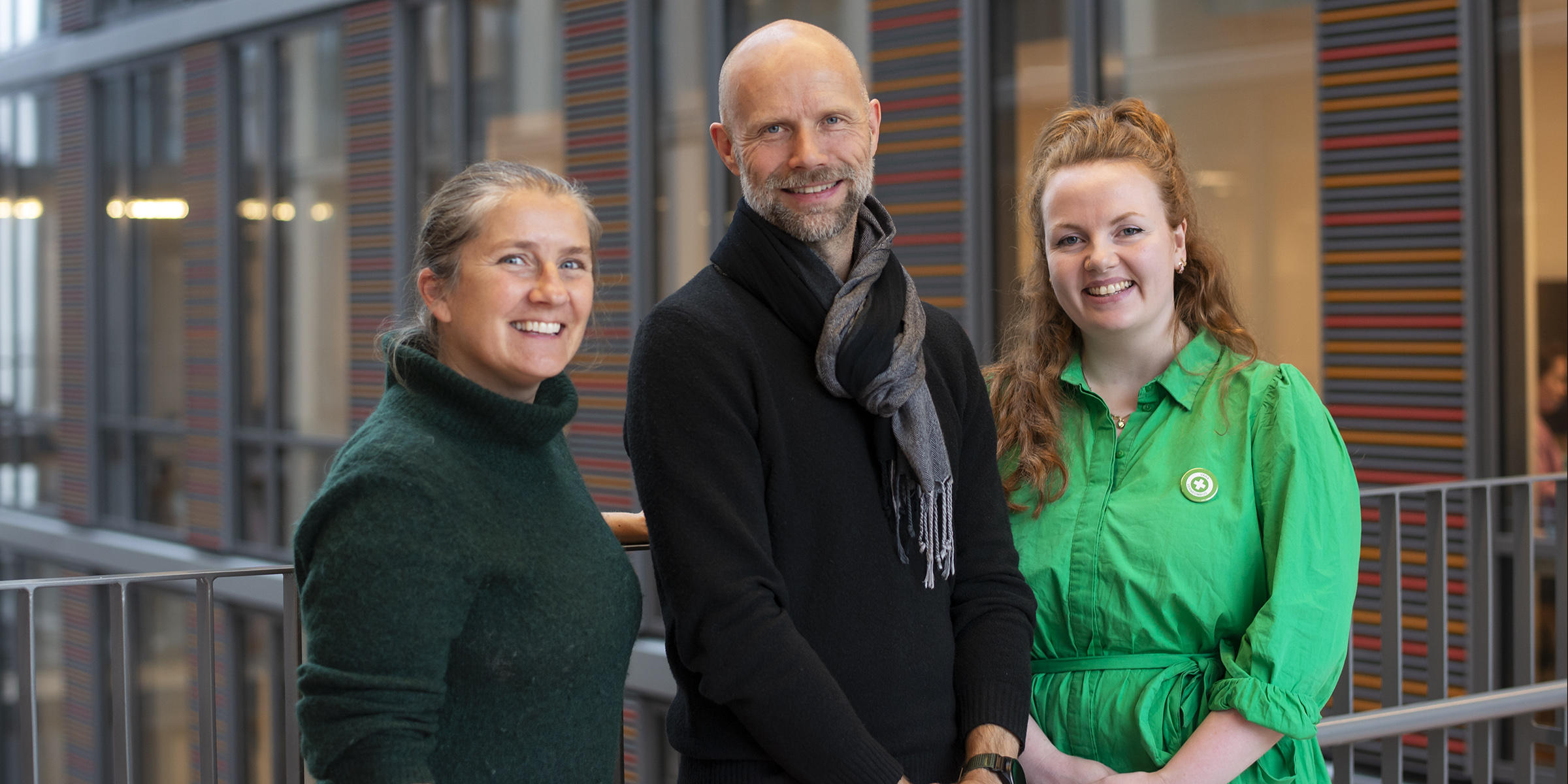Bilde av tre verneombud som står sammen inne på campus.