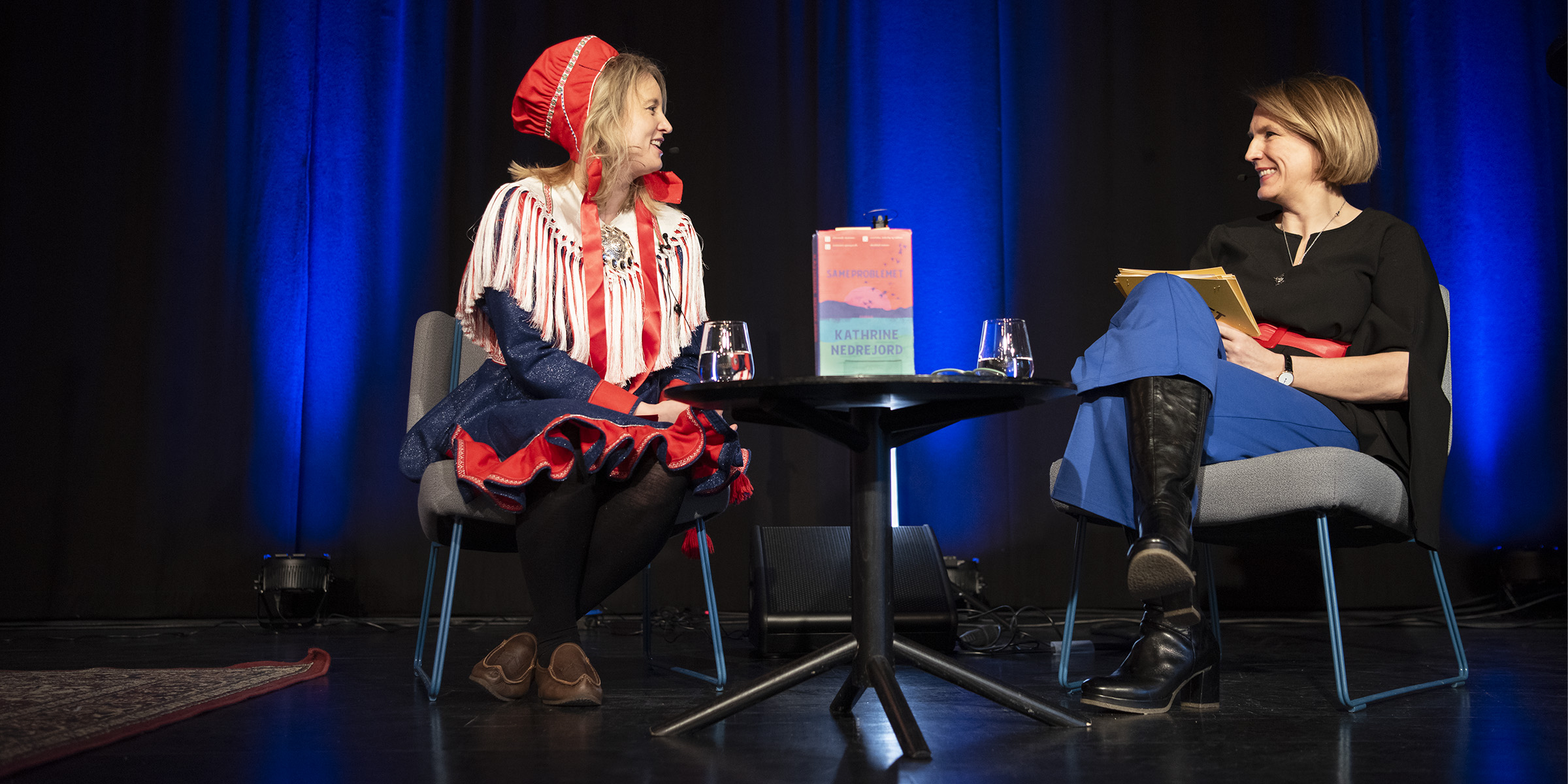 Foto av forfatter Kathrine Nedrejord sittende på scenen sammen med Vibeke Horn fra OsloMet som intervjuer henne.