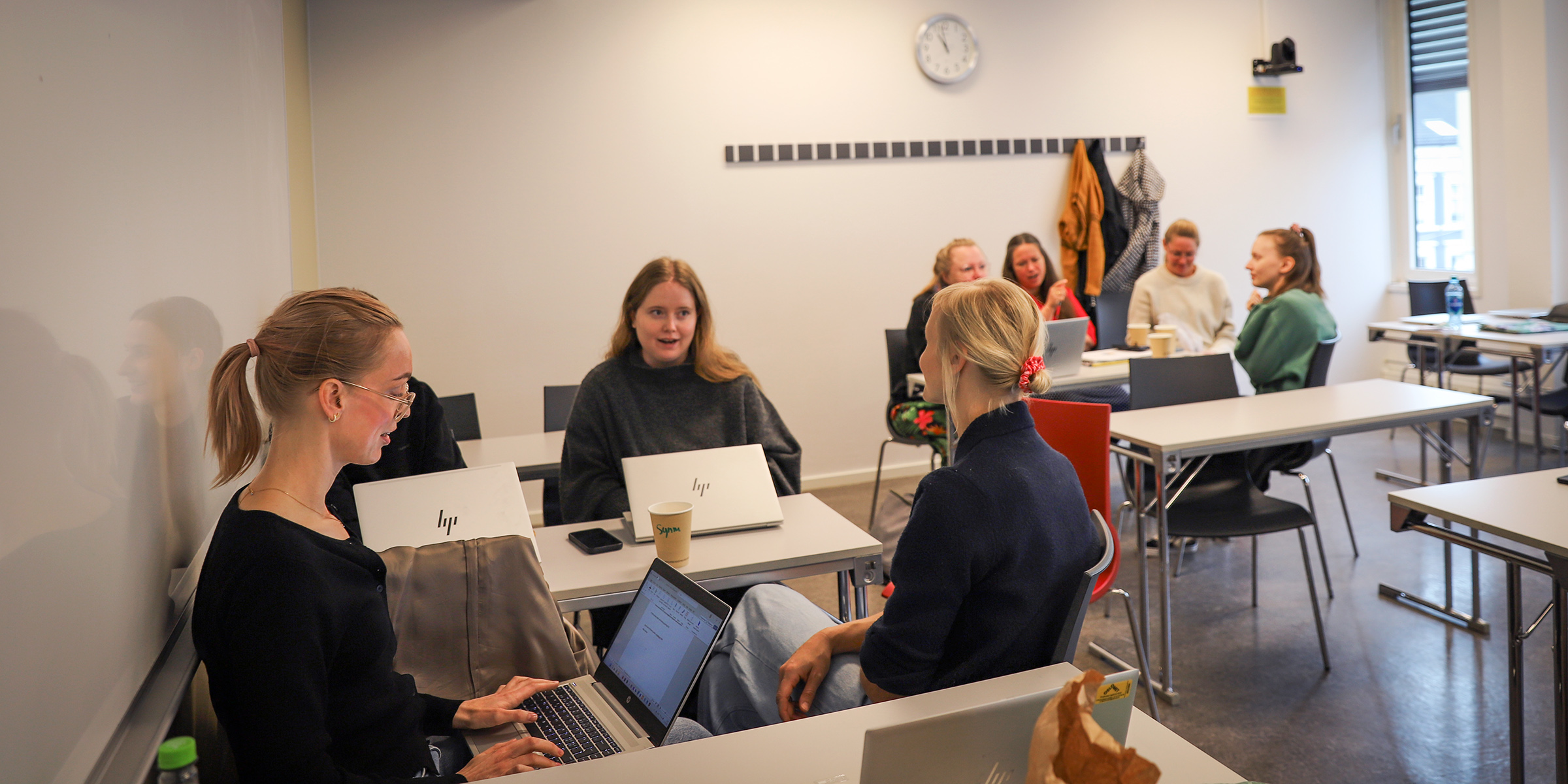 Bilde av klasserom med to grupper kursdeltakere som sitter sammen.