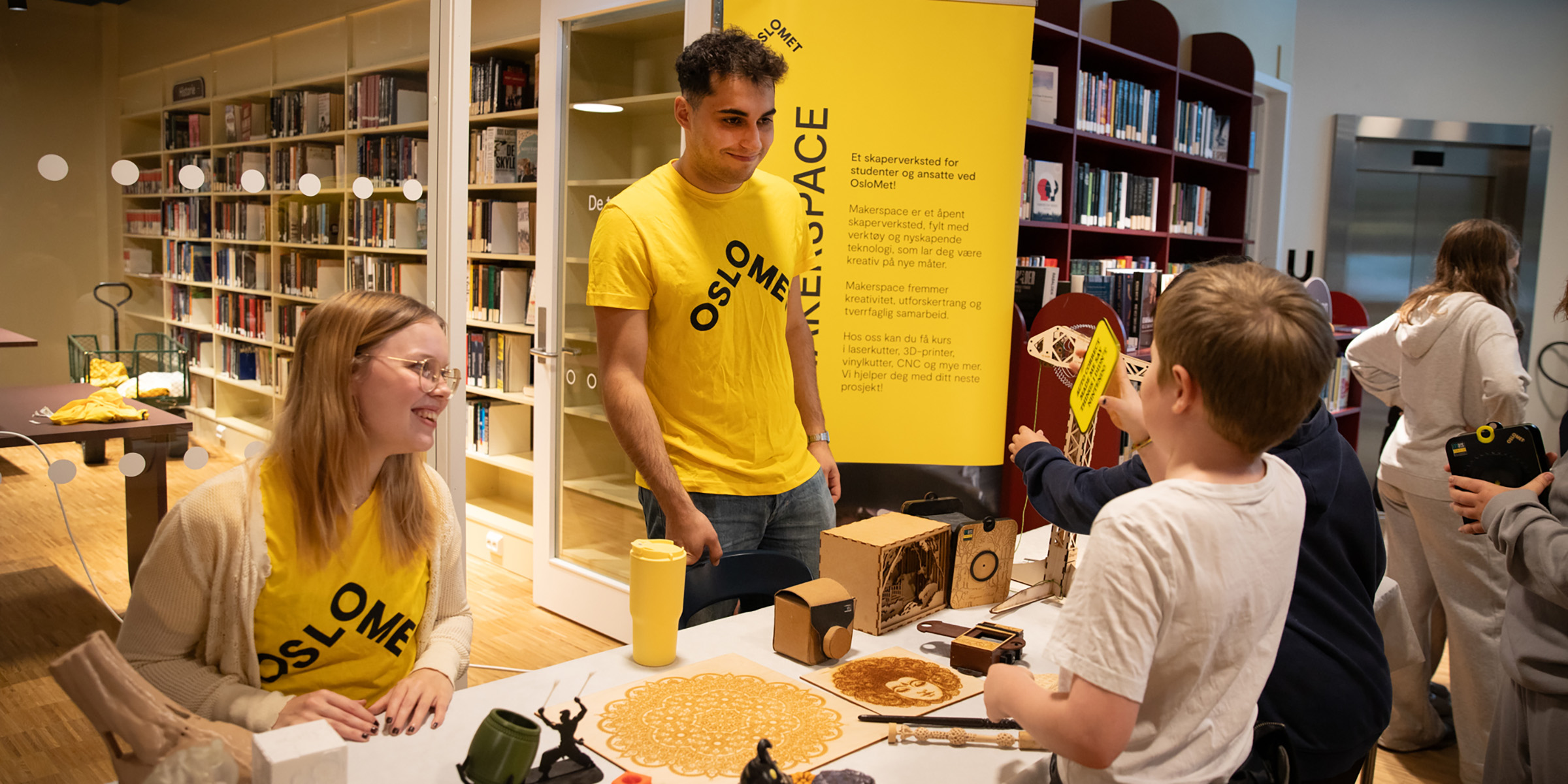 To studenter viser skoleelever3D-print med vaffellignende kunstverk.