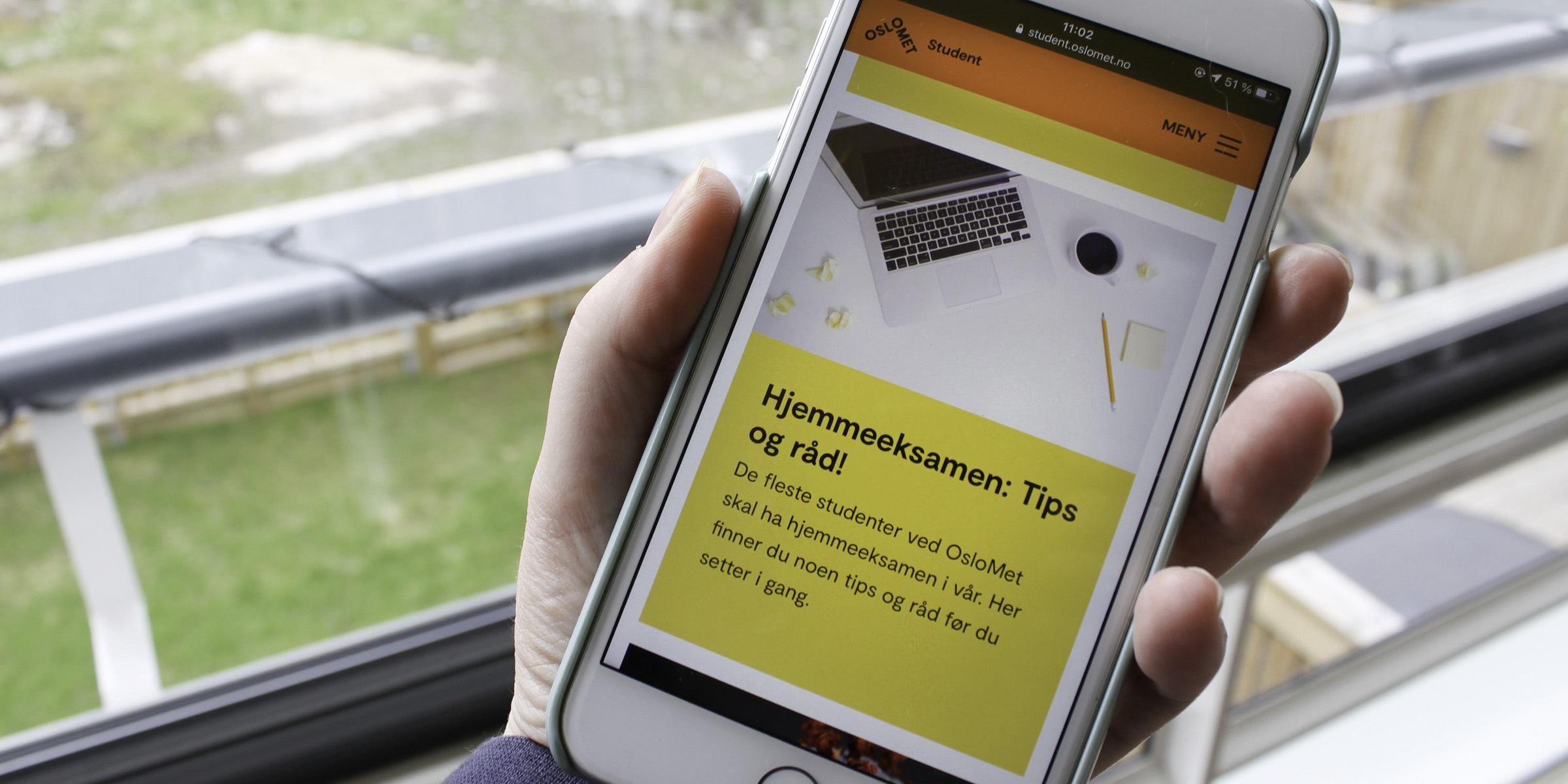 En hånd holder en mobiltelefon