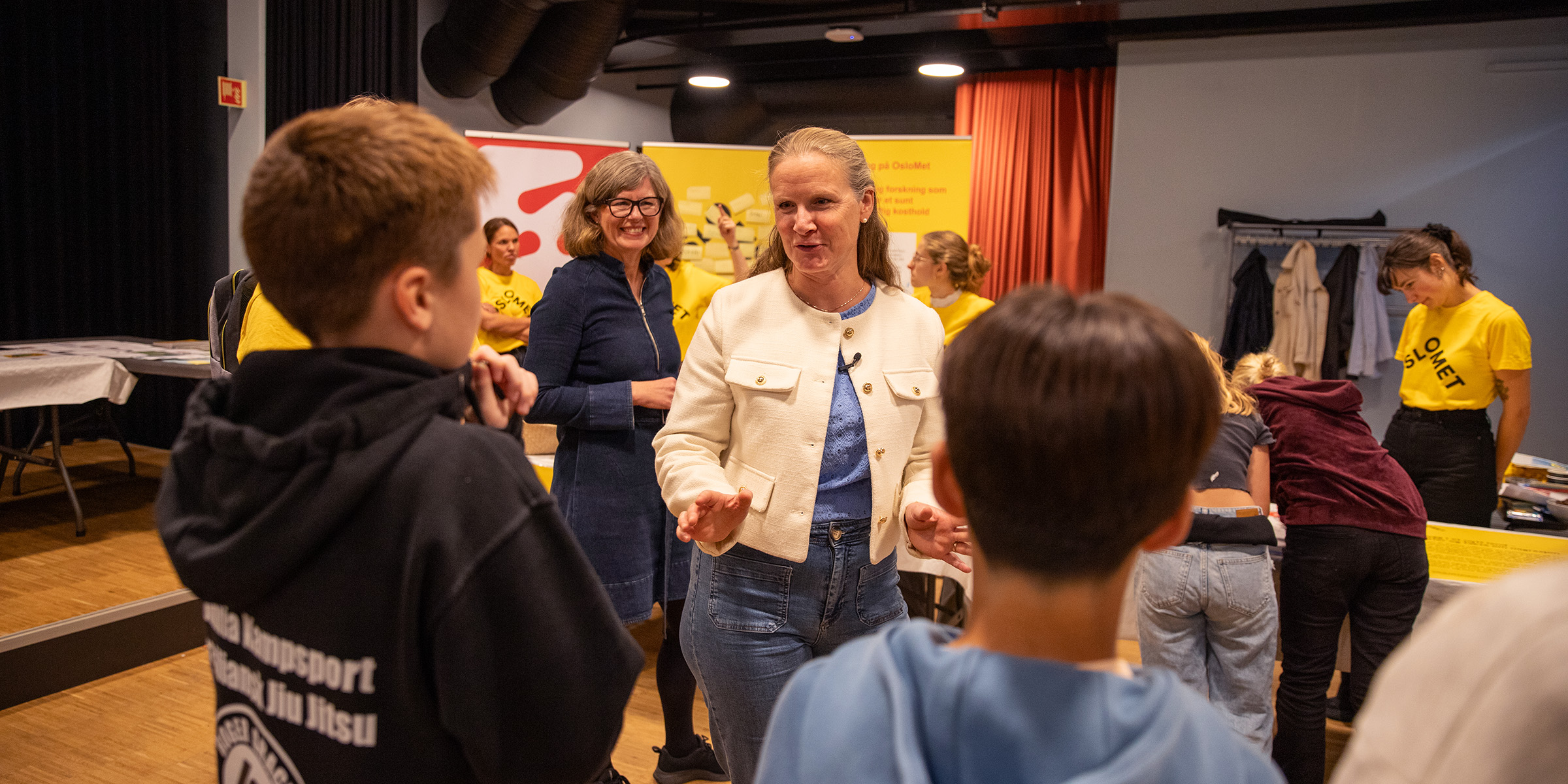 Bilde av Mari Sundli Tveit, Tanja Storsul og skoleelever på forskningstorget.