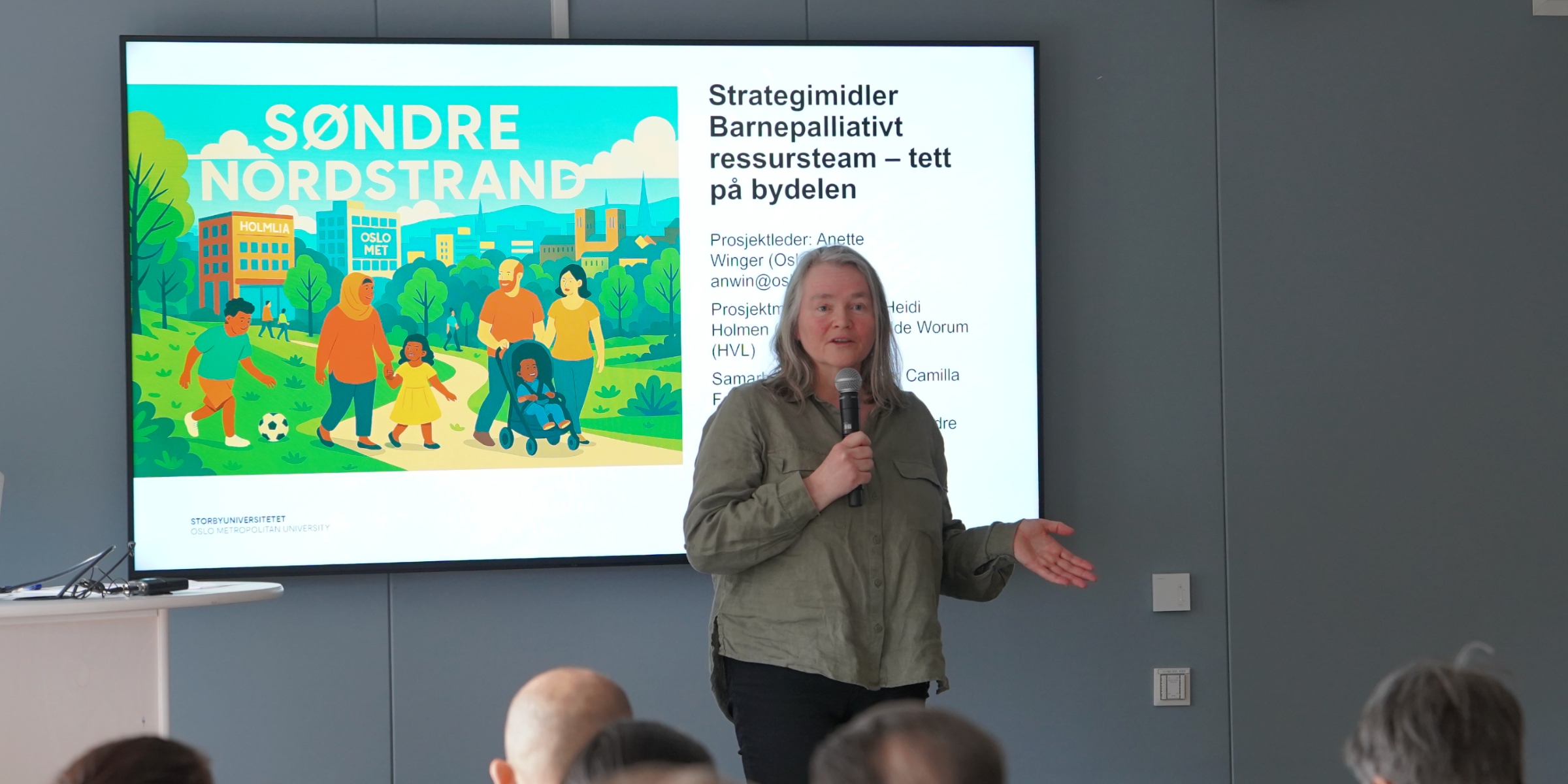  Anette Winger, professor i barnepalliasjon står og presenterer.