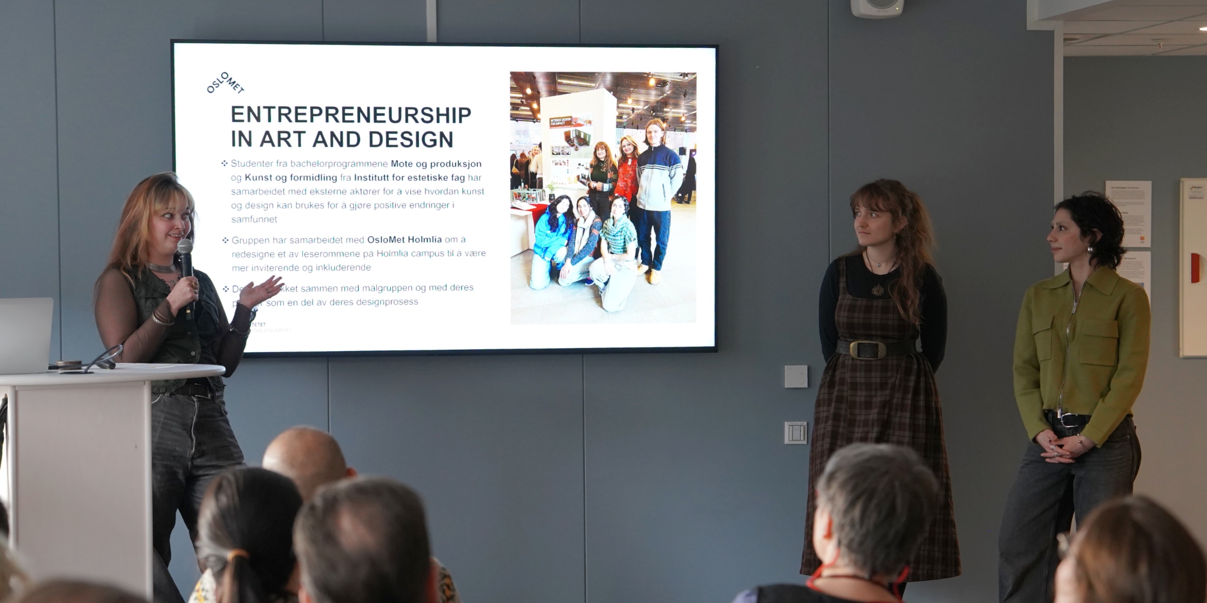  En av studentene står med mikrofon og presenterer.